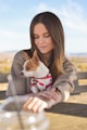 tilt-shift photography of woman behind short-coated white and brown puppy