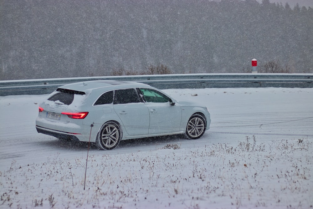 white 5-door hatchback near gray fence