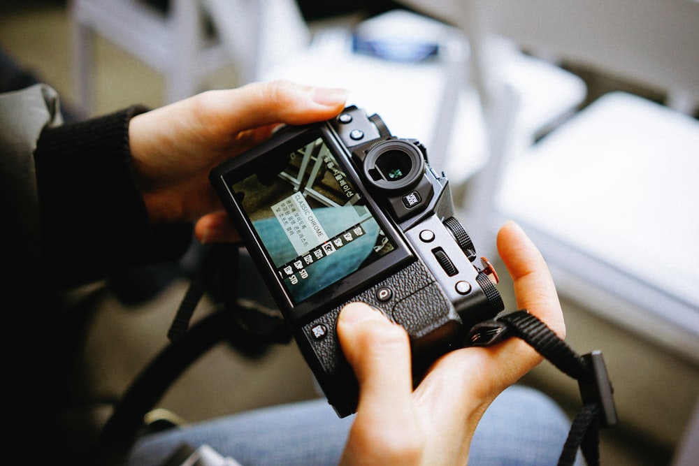 person holding black DSLR camera scanning for settings