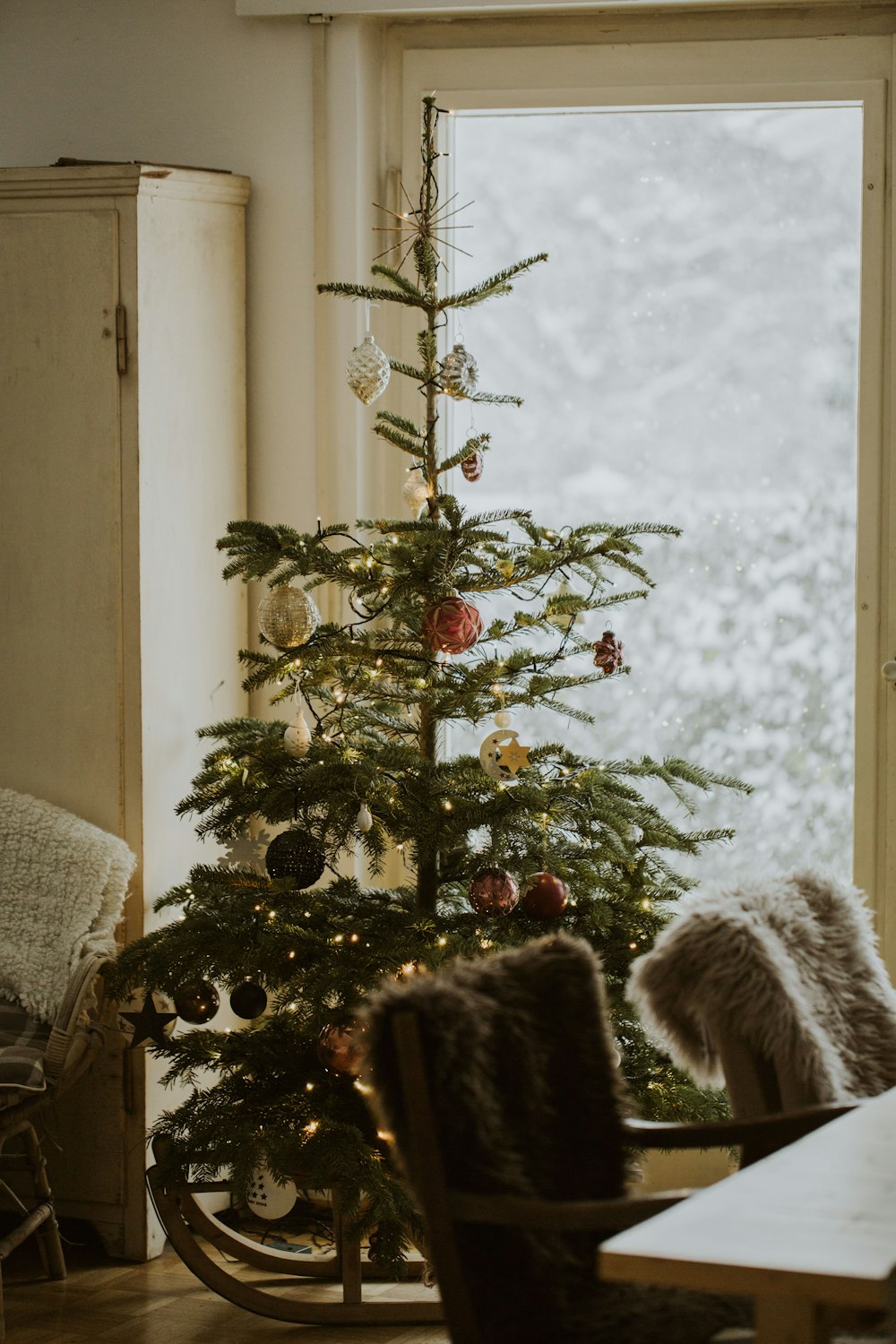 green Christmas tree with assorted-color baubles inside room