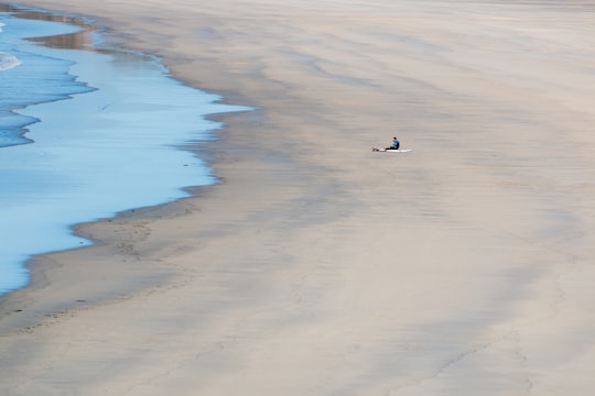 person sitting on seashore during daytime in Le Conquet France