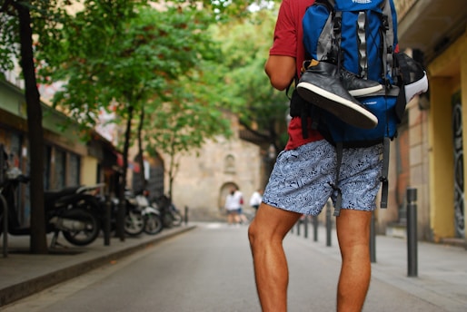 man standing on street carrying backpack