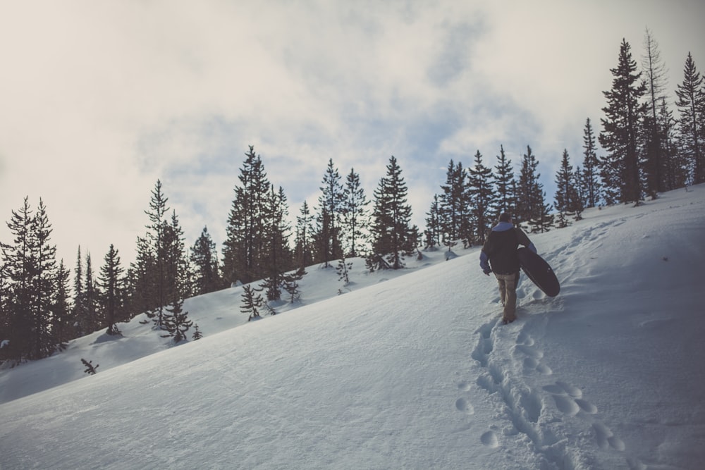 homme marchant sur la montagne enneigée