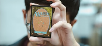 boy holding Magic: The Gathering trading card