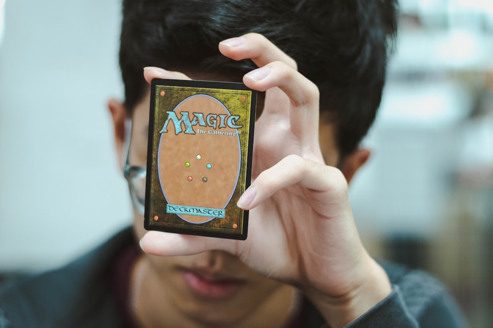 menino segurando Magic: The Gathering cartão de negociação
