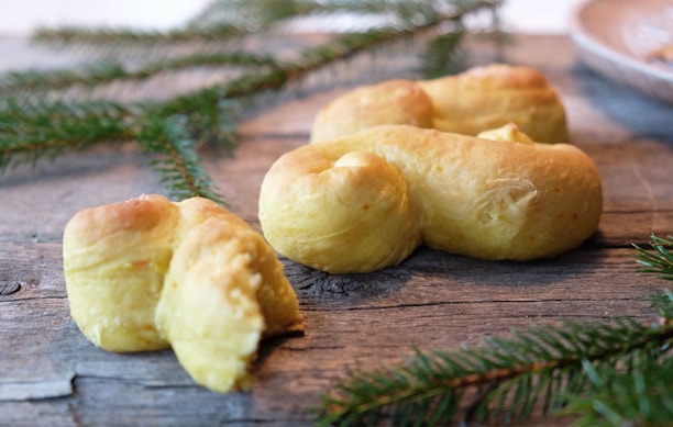Close-up of freshly baked panettones stacked in a rustic bakery setting.