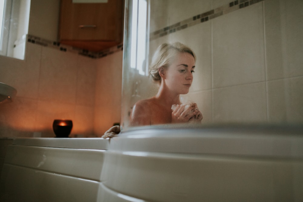 mujer desnuda sentada dentro de la bañera