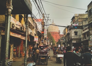 group of people on concrete road between buildings