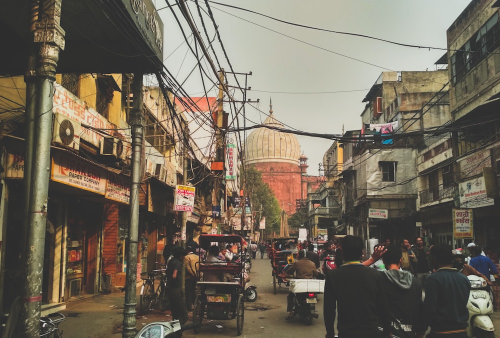 group of people on concrete road between buildings