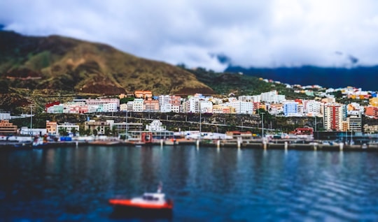 red motorboat on body of water near city buildings in La Palma Spain