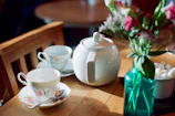 A cozy setting featuring a colorful teapot and matching mugs on a rustic wooden table.