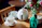 A cozy tea setting with a glass teapot and delicate cups on a wooden table.
