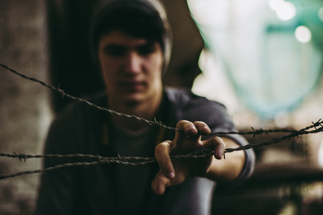 person wearing gray shirt holding barbwire