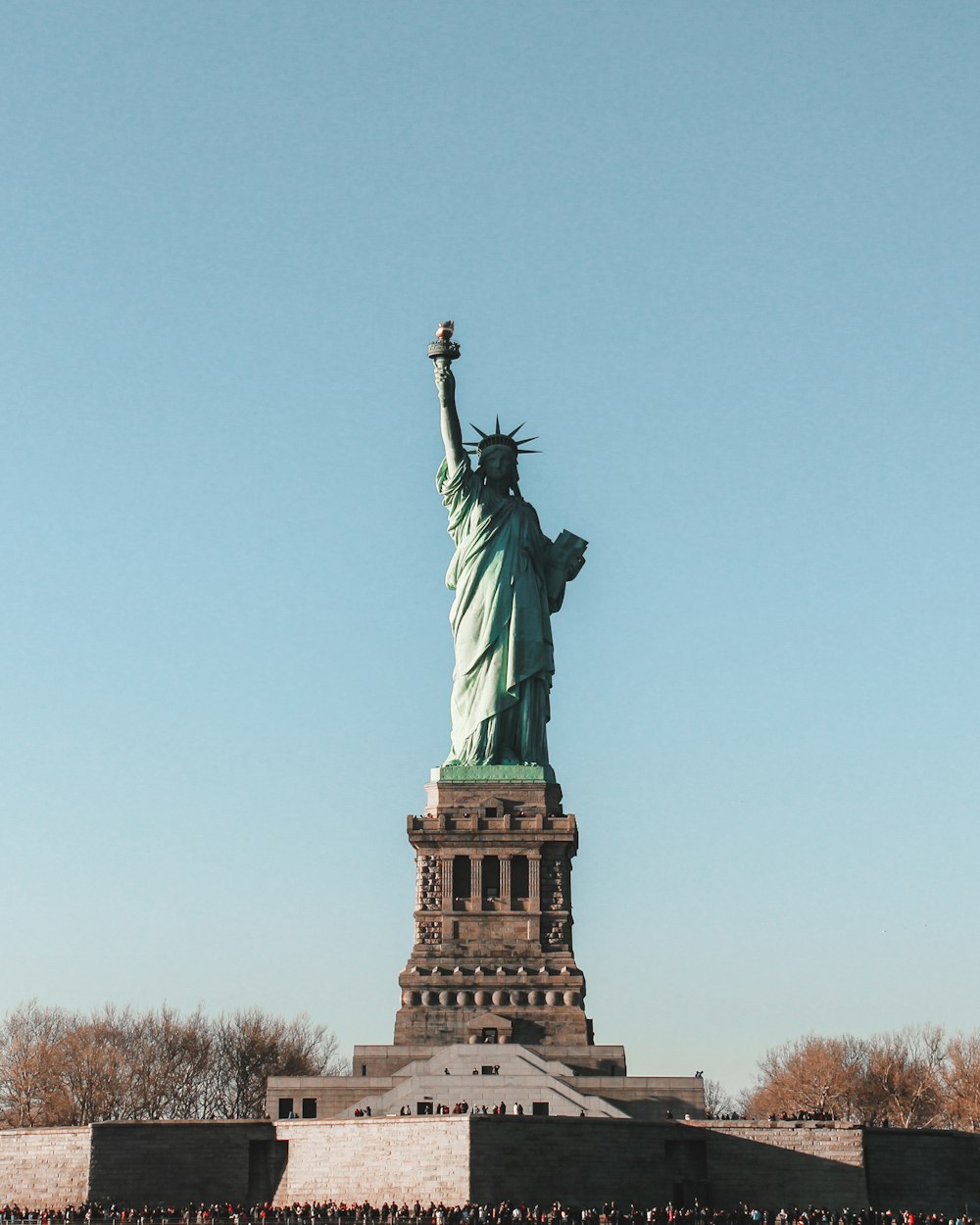 the statue of liberty is surrounded by a crowd of people