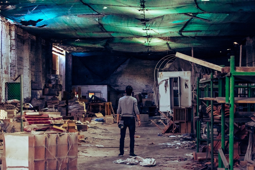 man standing near green steel scaffolding