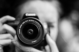 person taking photo using Canon camera in shallow focus lens