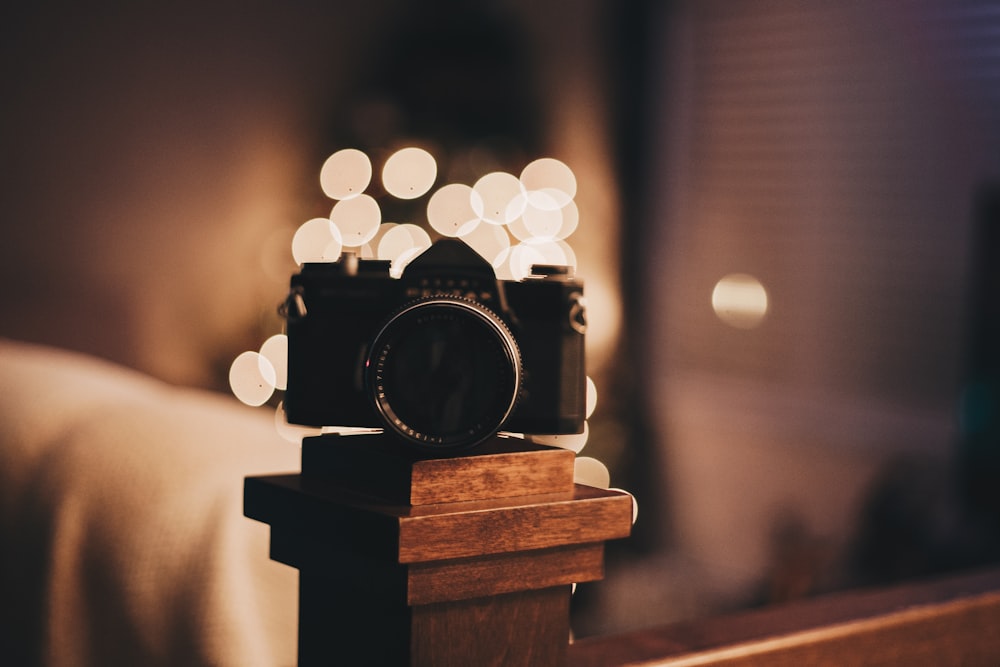 bokeh photography of camera on brown wooden baluster