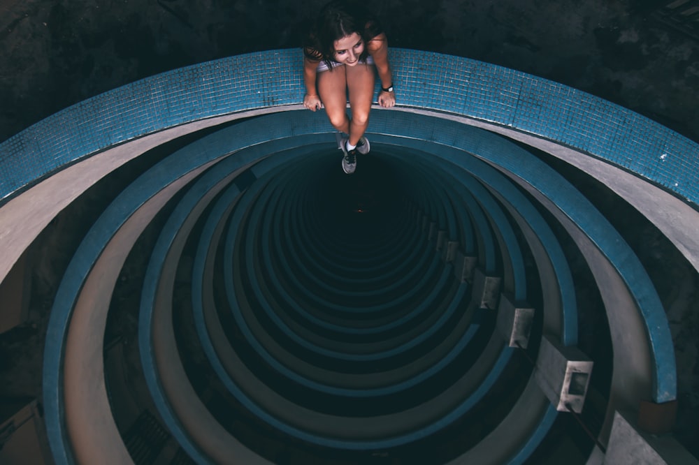 woman sitting on blue and gray building