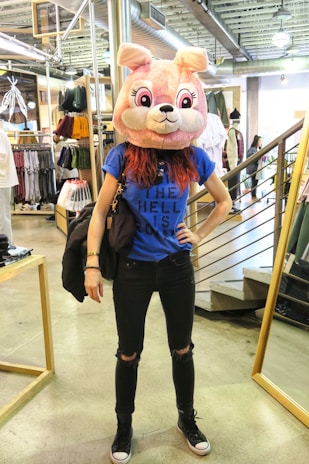 Customer wearing a grunge-style animal mask in a moody, dimly lit room with layered scrapbook elements.