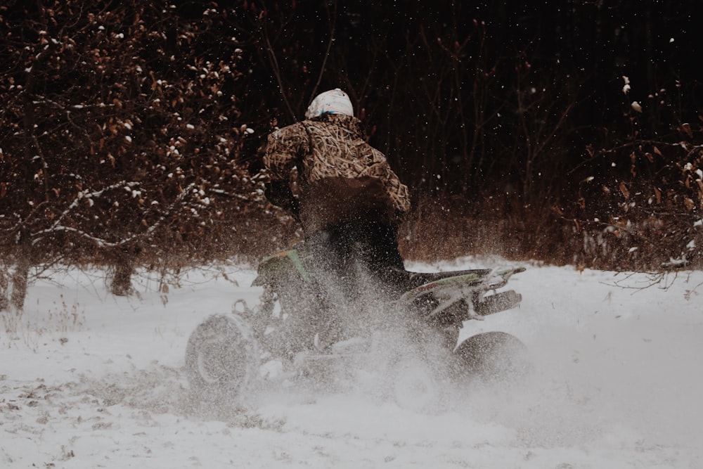 person using ATV on snow ground during daytime