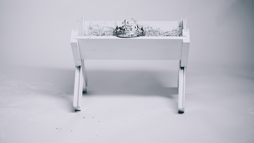 fotografia in scala di grigi della tiara sul tavolo