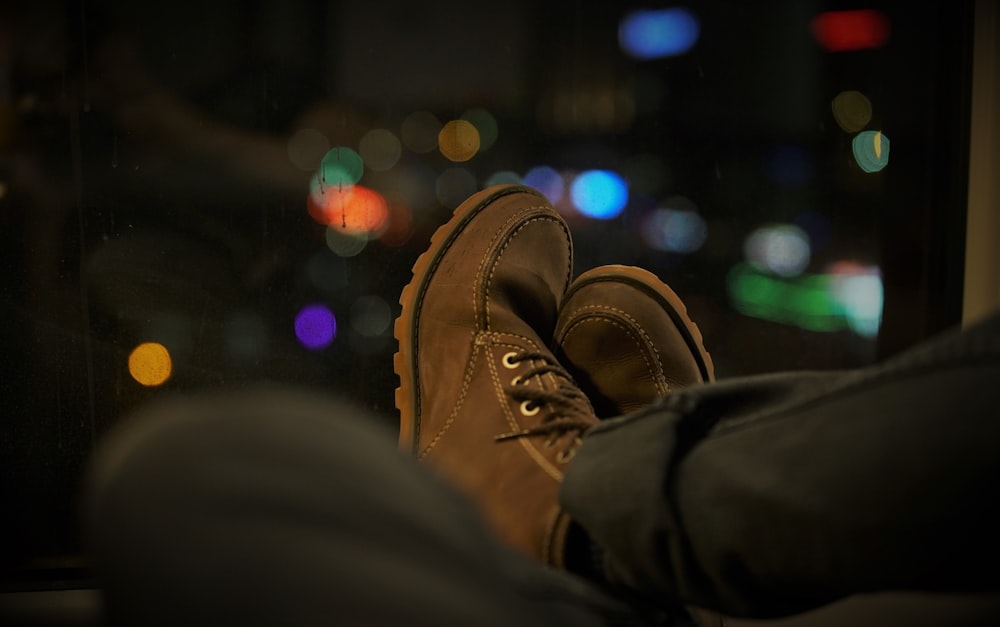 person wearing black pants and brown boots sitting