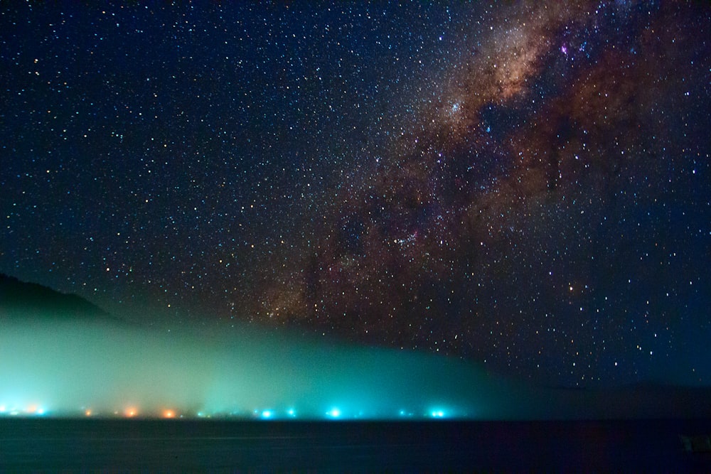 city surrounded by fog under milky way