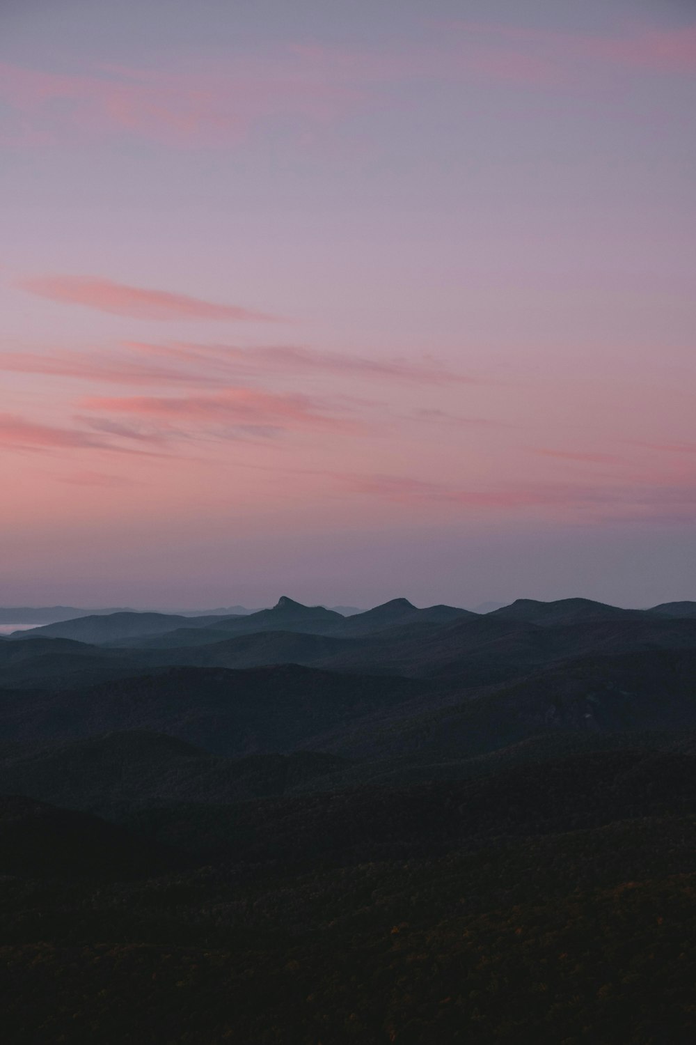 silhouette of mountains under pink sky