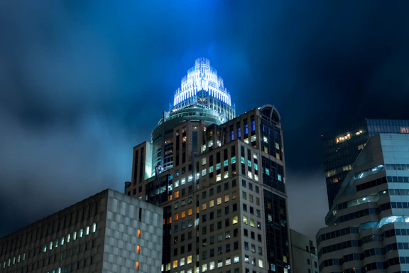 Futuristic office building glowing with neon blue and violet lights against a dark sky, symbolizing global connectivity.