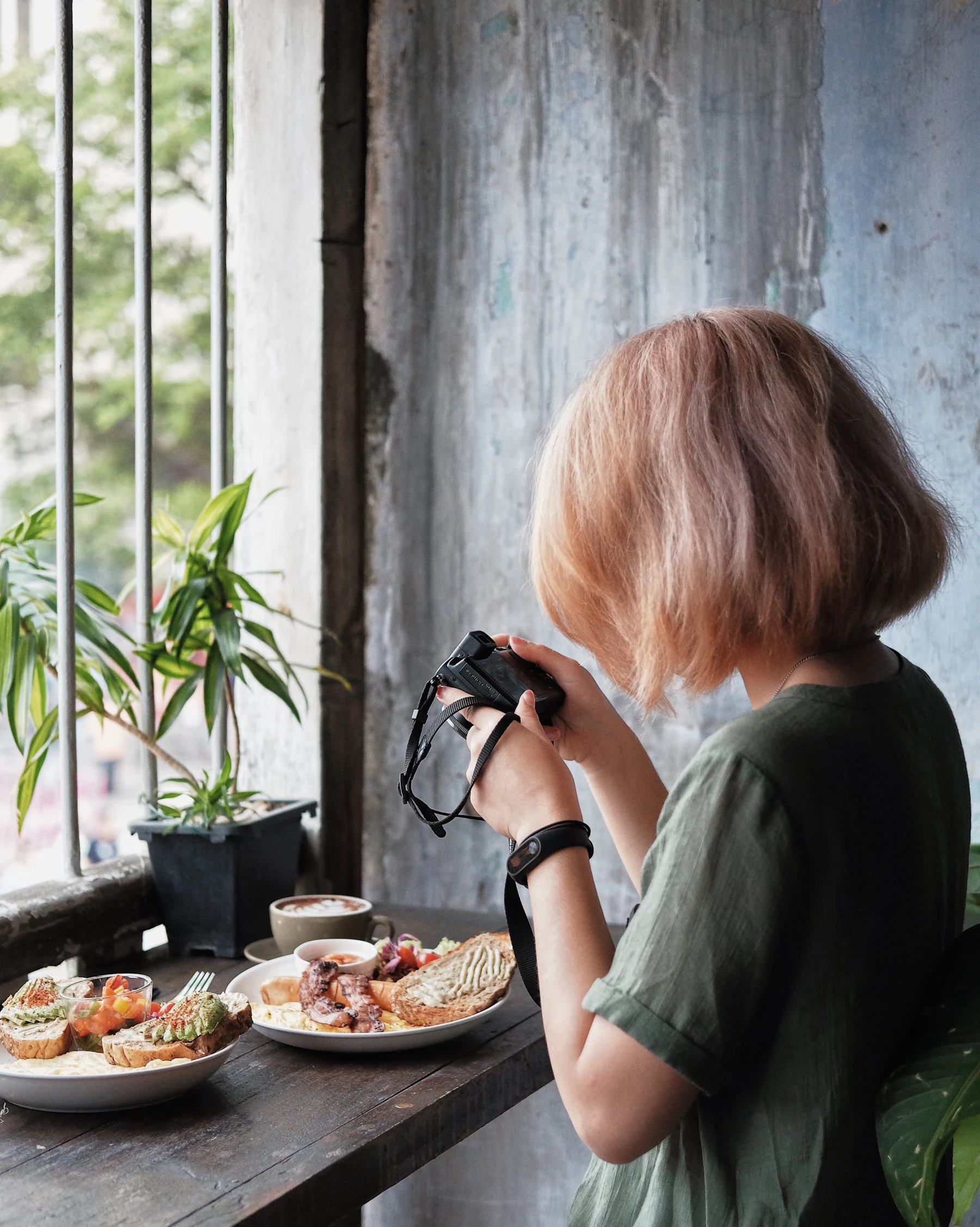 Woman taking a photo of her food in a café