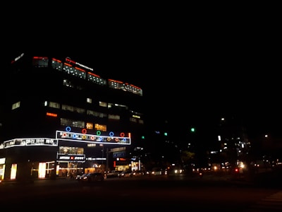 Close-up of illuminated signage glowing at night on a commercial building.