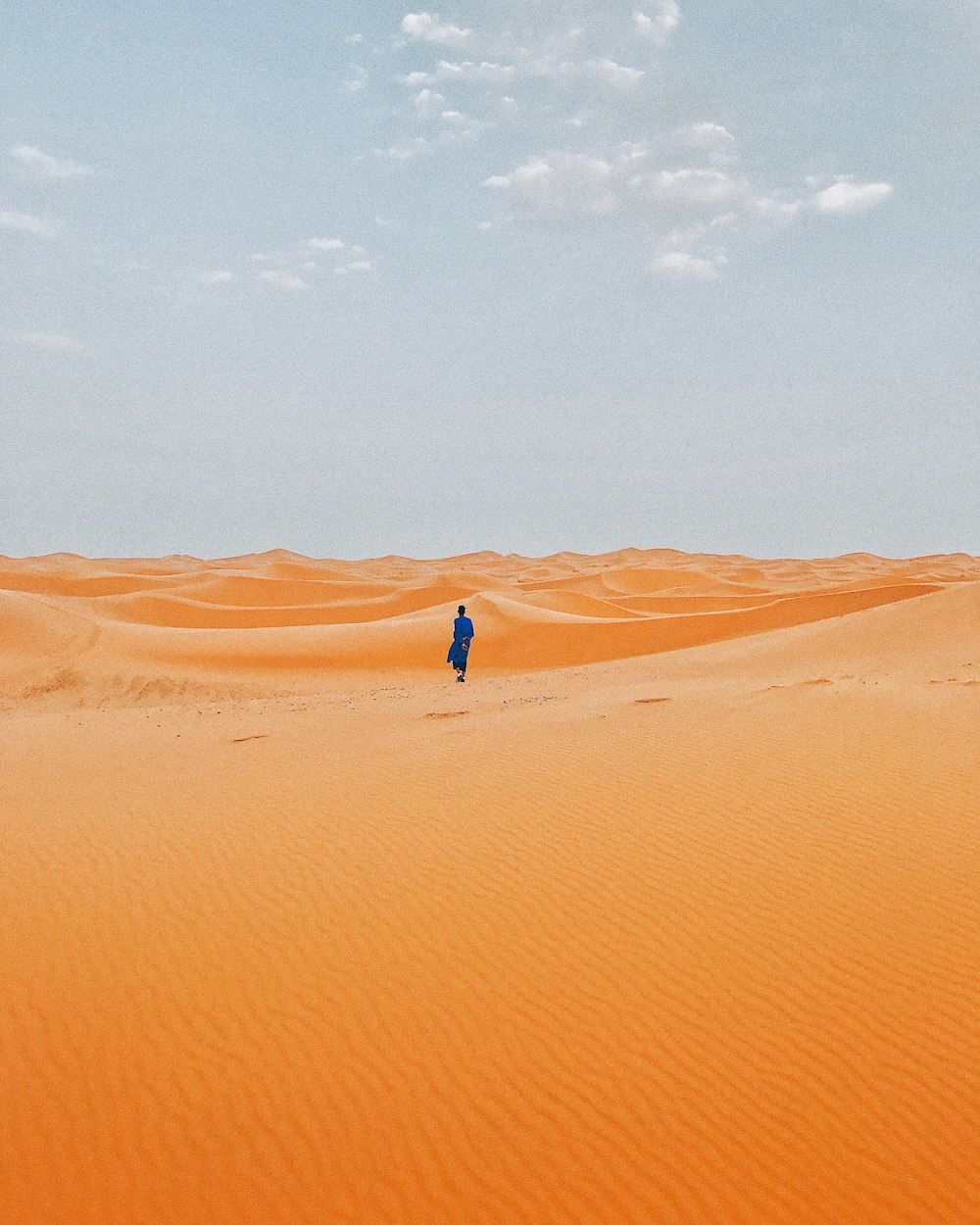 낮에 사막 한가운데에 서 있는 사람