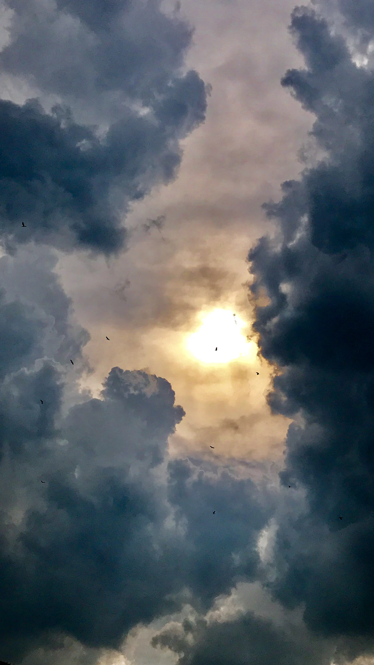 Matahari bersinar melalui celah awan badai yang gelap