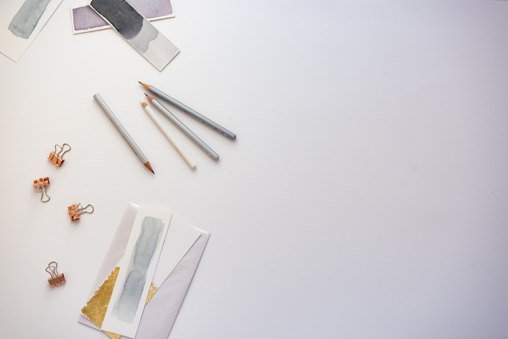 high angle photo of four pencils and greeting card