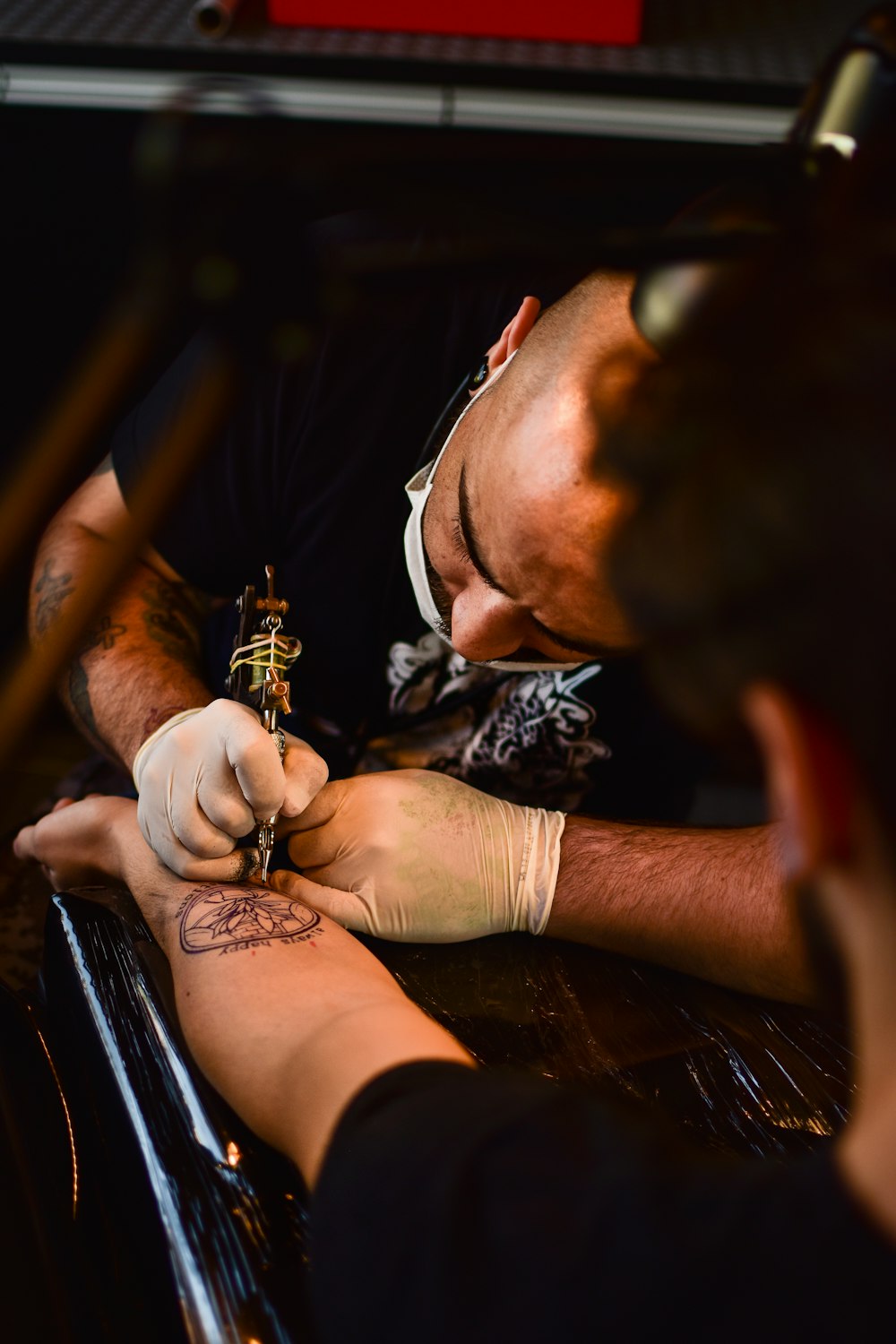 homem fazendo tatuagem no braço humano