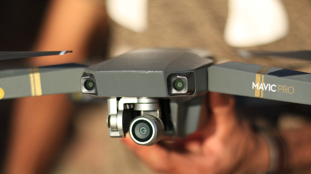 persona che tiene in mano il drone DJI Mavic Pro grigio