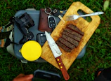 Handcrafted acacia wood barbecue board with knife and steak