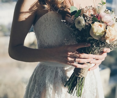 woman in white floral strapless dress holding flowers