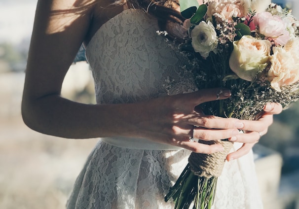 woman in white floral strapless dress holding flowers