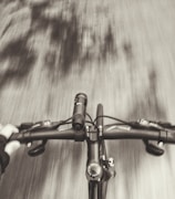 Close-up of hands gripping scooter handlebars in motion.