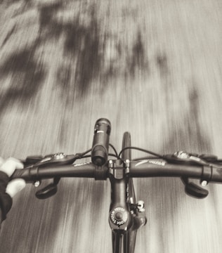 Close-up of hands gripping scooter handlebars in motion.