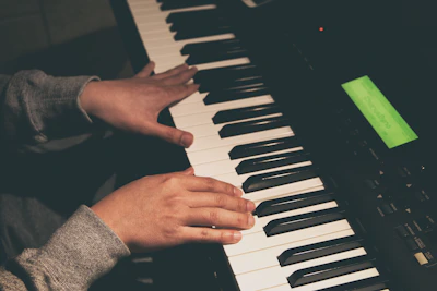 Hands adjusting the Sonarízate device on a piano keyboard with soft natural light