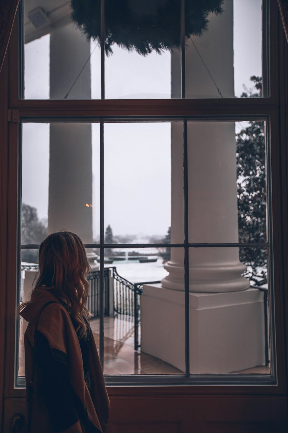 woman standing in front of window inside room