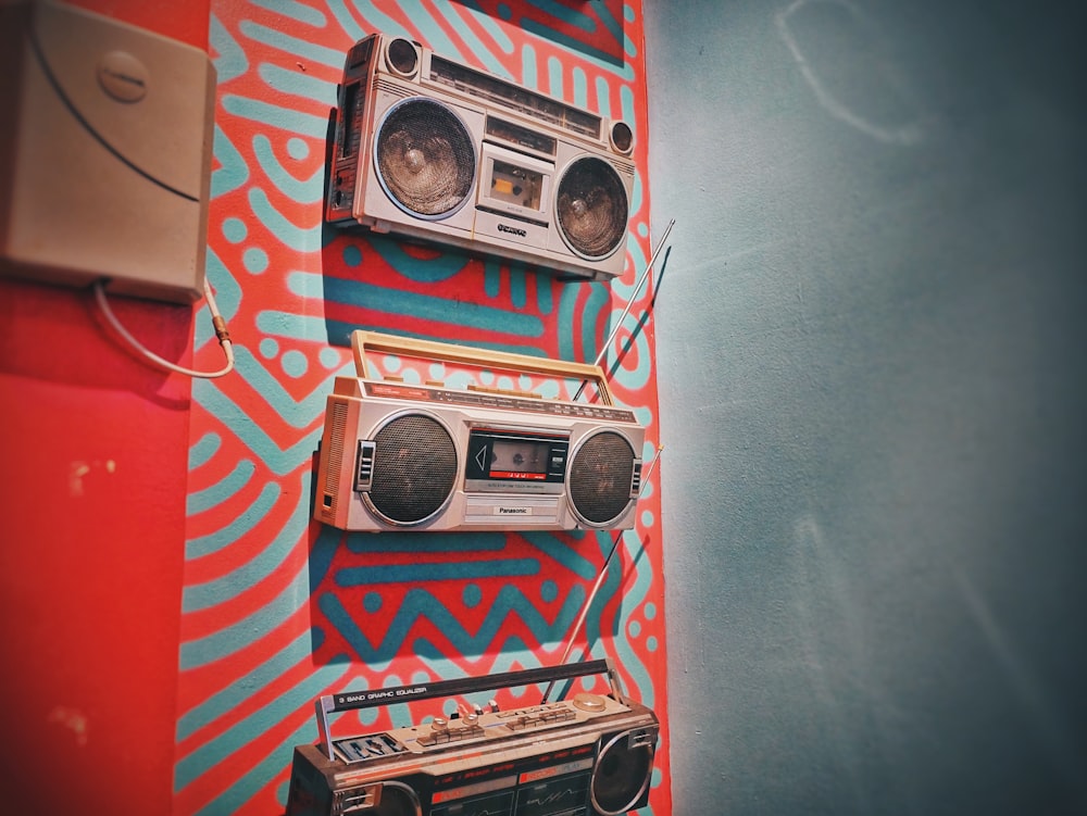 trois boombox grises accrochées au mur