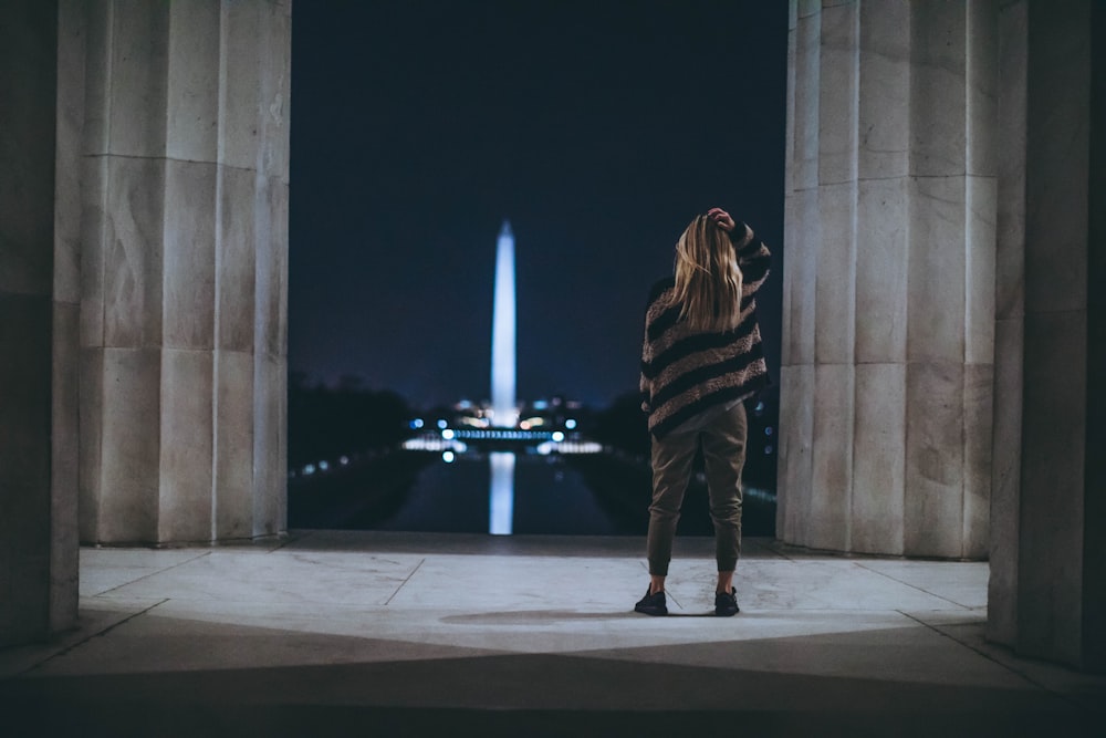 woman standing inside building facing tower landmark