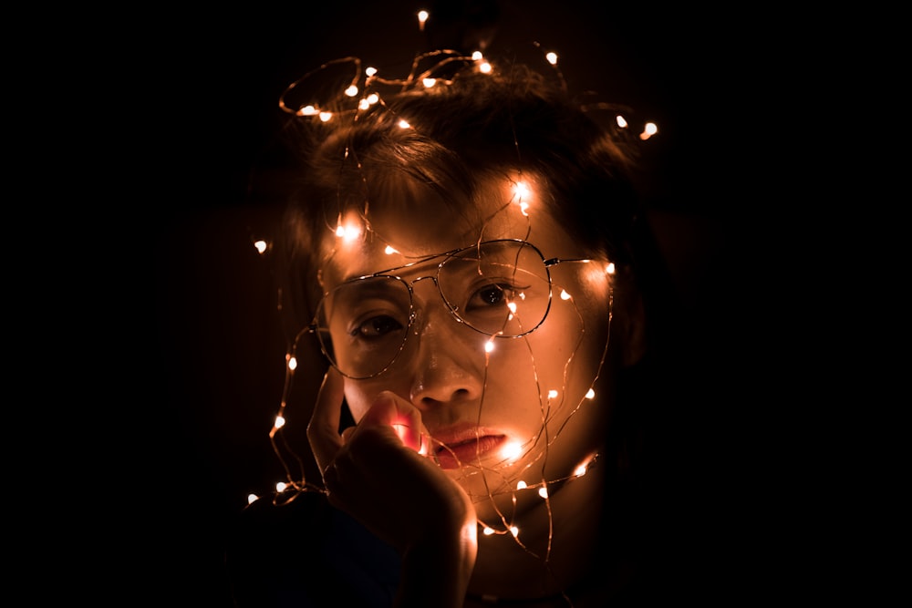 fotografia do retrato da luz da corda da mulher usando óculos