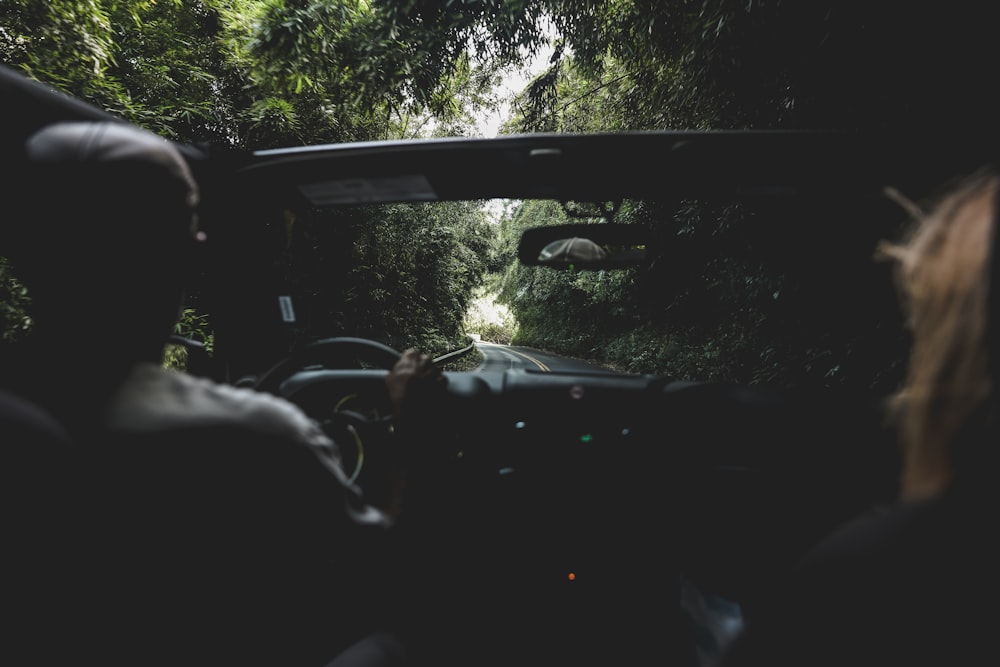 two people riding in car on road