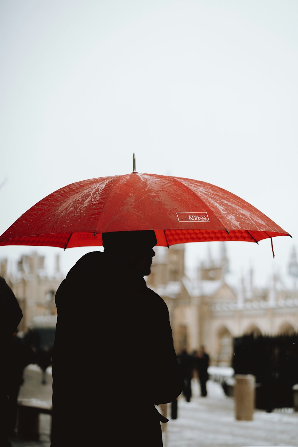 silhouette of person using umbrella at daytime photography