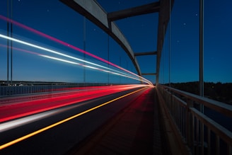 gray suspension bridge with streaks of light time lapse photography