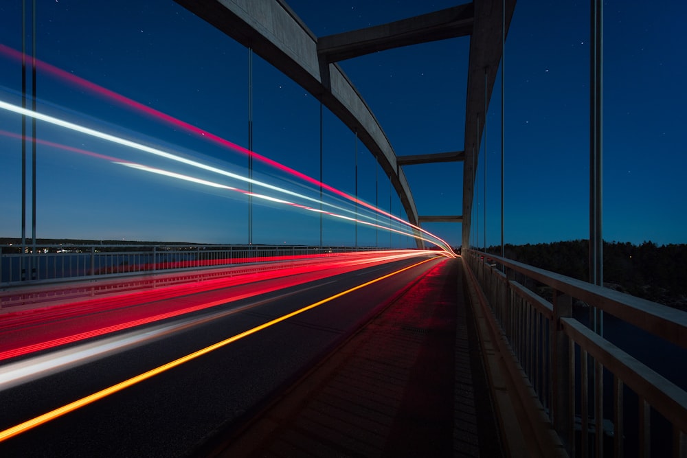 gray suspension bridge with streaks of light time lapse photography